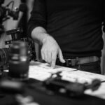 Fotograf prüft Auswahl von Bildern auf Kontaktabzügen am Tisch